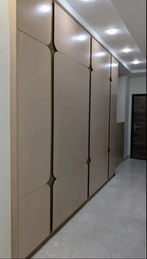 Beige handle-less wardrobe with sculpted grip grooves