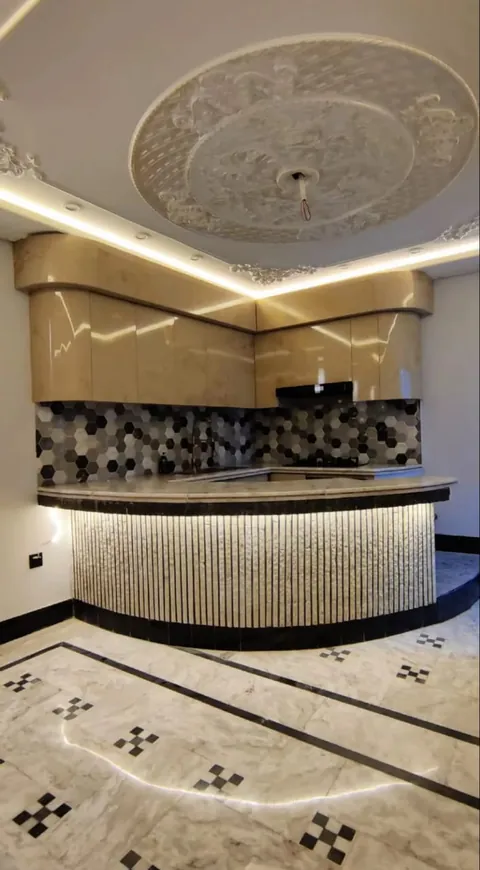 Curved bar counter with mosaic backsplash under a 3D false ceiling
