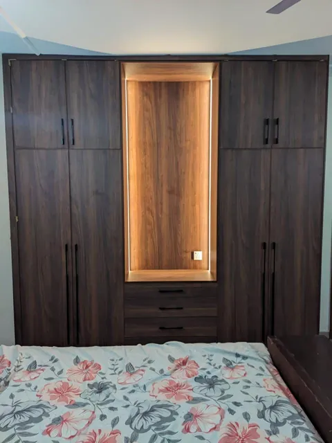 Dark walnut bedroom wardrobe with a lit centre niche