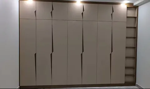 Full wall beige wardrobe with grip handles and open end shelving