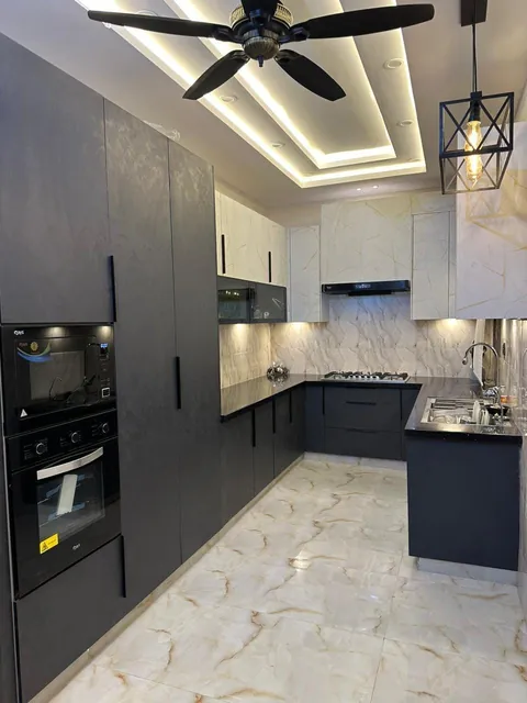Grey and charcoal L-shaped kitchen with a built-in oven