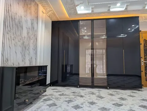 Lounge with a marble-look feature wall, electric fireplace and black glass wardrobe