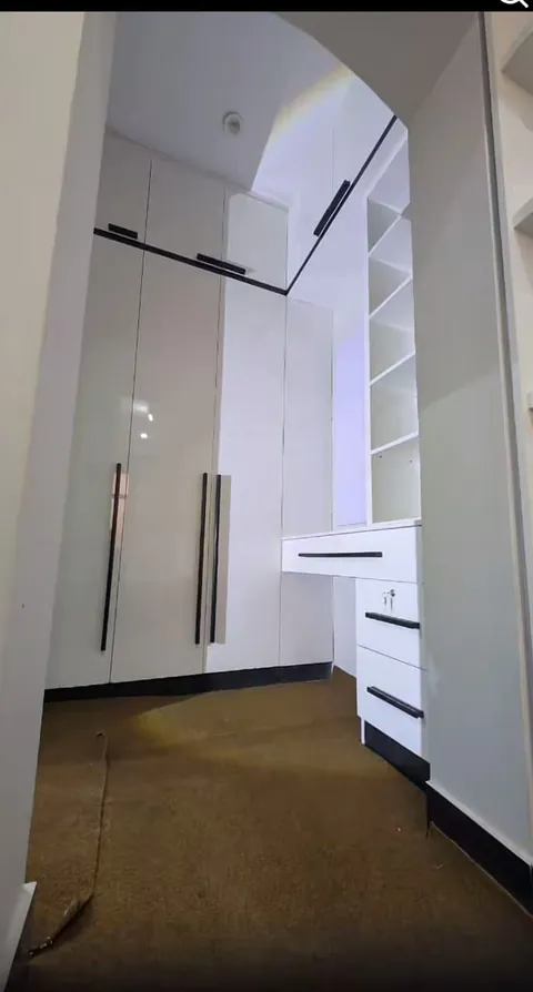 White built-in wardrobe with a study desk and open shelves